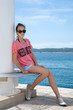 Foto: Teenage girl sitting by the sea Teenage girl sitting by the sea
