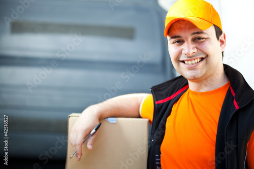 Photo: Smiling guy delivering a box Smiling guy delivering a box