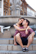 Affectionate young couple sitting by the fountain