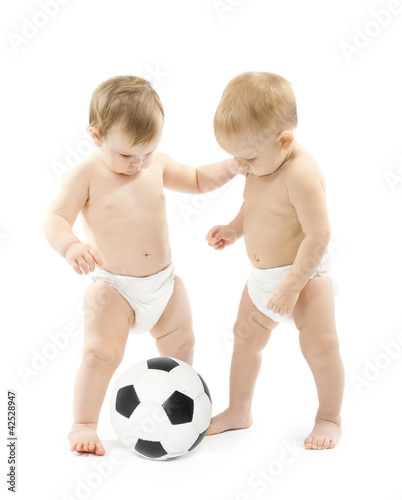 Photo: Two babies playing soccer ball over white background. Kids physi Two babies playing soccer ball over white background. Kids physi