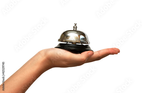 Photo: woman hand giveing a hotel service bell woman hand giveing a hotel service bell