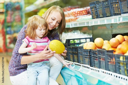Photo: woman and little girl shopping fruits woman and little girl shopping fruits