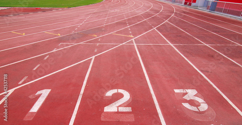 Photo: Lanes of a red race track with numbers and red seats in the stad Lanes of a red race track with numbers and red seats in the stad