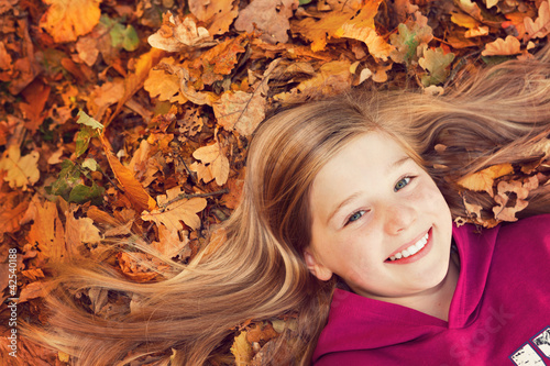 Foto: girl on autumn leaves smiling girl on autumn leaves smiling