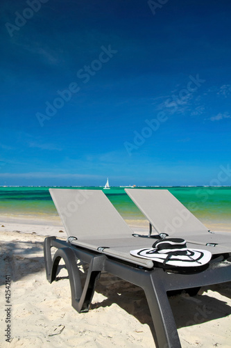 Photo: Sun hat on beach chaise longues Sun hat on beach chaise longues
