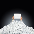 Photo: Person under crumpled pile of papers with hand holding a help si Person under crumpled pile of papers with hand holding a help si