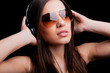 Photo: Beautiful young woman listening to music with headphones on blac Beautiful young woman listening to music with headphones on blac