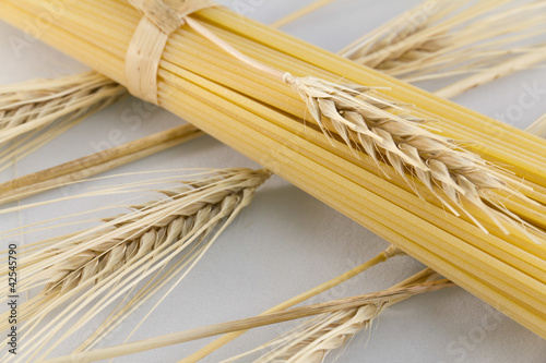 Photo: Pasta, spaghetti and corn ears on white background Pasta, spaghetti and corn ears on white background