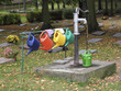 Bunte Gießkannen auf einem Friedhof