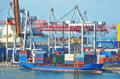 Photo: Container stack and ship under crane bridge Container stack and ship under crane bridge