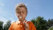 Little boy blowing dandelion on the meadow