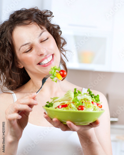 Photo: Diet. Beautiful Young Woman Eating Vegetable Salad Diet. Beautiful Young Woman Eating Vegetable Salad