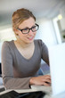 Beautiful young woman studying at home on laptop