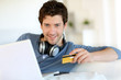 Young man buying music on internet with tablet