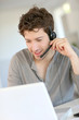 Student at home working with laptop and headset