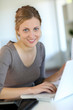 Beautiful young woman studying at home on laptop