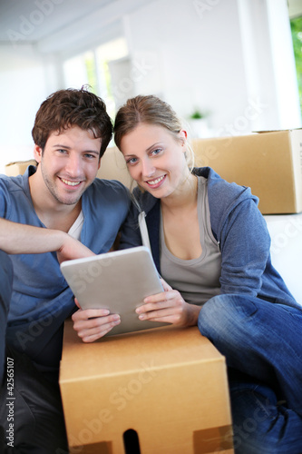 Photo: Young couple using tablet to find transport company Young couple using tablet to find transport company