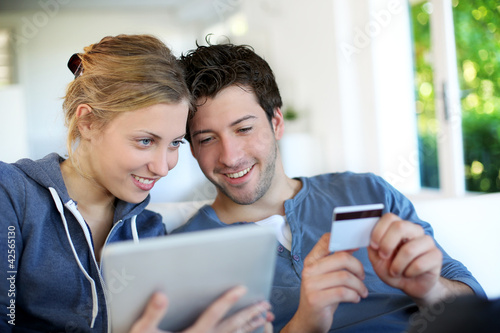 Foto: Happy young couple doing shopping on internet Happy young couple doing shopping on internet