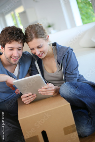 Photo: Young couple using tablet to find transport company Young couple using tablet to find transport company
