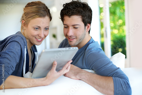 Foto: Young couple using electronic tablet Young couple using electronic tablet