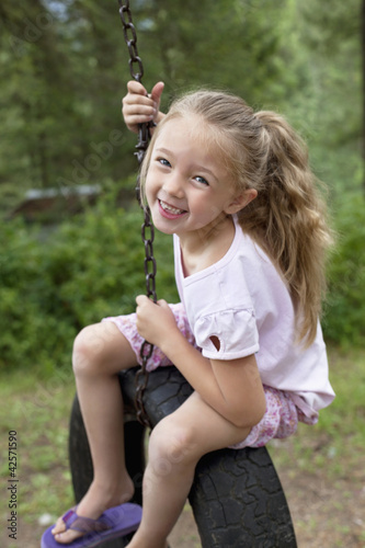 Photo: Portrait of young swinging on tire Portrait of young swinging on tire
