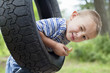 Foto: Portrait of a young boy winking while swinging on tire Portrait of a young boy winking while swinging on tire