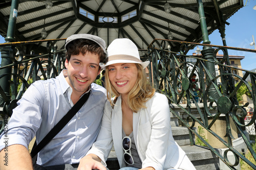 Photo: Romantic couple sitting by gazebo in touristic area Romantic couple sitting by gazebo in touristic area