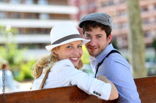 Foto: Lovely young couple sitting on public bench Lovely young couple sitting on public bench