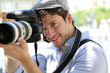 Portrait of young photographer holding camera