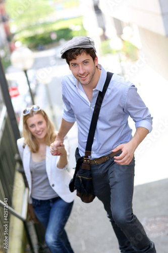 Photo: Young romantic couple climbing stairs in town Young romantic couple climbing stairs in town