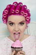 Foto: Portrait of a young woman licking cupcake Portrait of a young woman licking cupcake