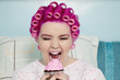 Foto: Young woman with open mouth holding cupcake Young woman with open mouth holding cupcake