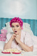 Shocked young woman with popcorn lying on bed while looking away