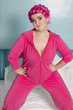Photo: Portrait of young woman exercising with hands on hips standing on bed Portrait of young woman exercising with hands on hips standing on bed
