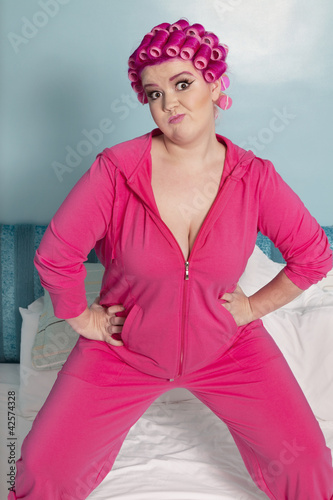 Photo: Portrait of young woman exercising with hands on hips standing on bed Portrait of young woman exercising with hands on hips standing on bed
