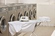 Foto: Ironing board with washing machines in Laundromat Ironing board with washing machines in Laundromat