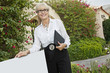 Photo: Portrait of a happy senior woman standing by sign board with clipboard Portrait of a happy senior woman standing by sign board with clipboard