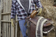 Midsection of a mature man holding horse riding tack