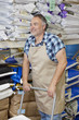 Photo: Happy mature man pushing cart in feed store Happy mature man pushing cart in feed store