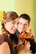 Young couple drinking cocktails in bar or restaurant