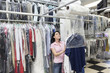 Foto: Happy mid adult woman looking up while putting clothes in plastic Happy mid adult woman looking up while putting clothes in plastic