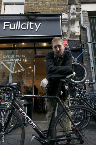 Photo: Portrait of mid adult man standing outside cycle shop Portrait of mid adult man standing outside cycle shop