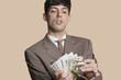 Foto: Young businessman counting money over colored background Young businessman counting money over colored background