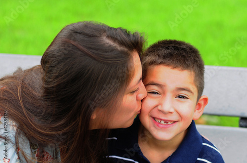 Photo: Mom kissing young son on cheek Mom kissing young son on cheek