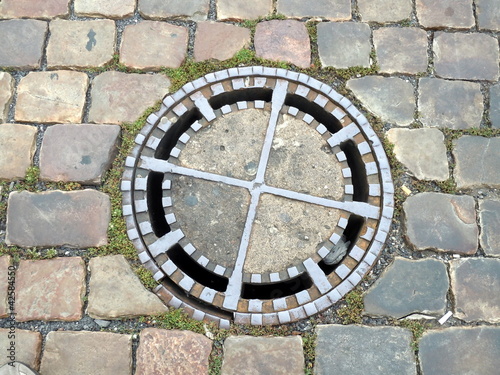 Foto: rock ground with an iron manhole cover rock ground with an iron manhole cover