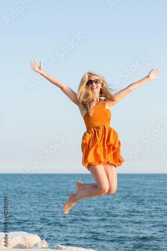 Foto: Frau springt am Strand Frau springt am Strand