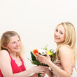 Woman giving her friend a bouquet