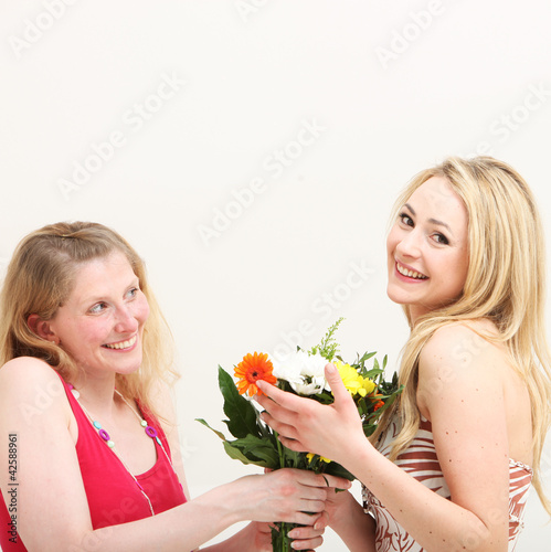 Photo: Woman giving her friend a bouquet Woman giving her friend a bouquet