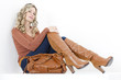 sitting woman wearing fashionable brown boots with a handbag
