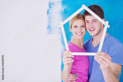 Photo: happy couple paint wall at new home happy couple paint wall at new home